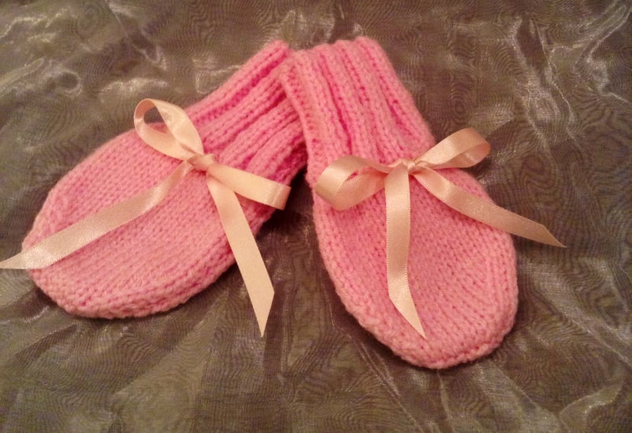 Little pink knitted baby mittens