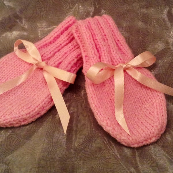 Little pink knitted baby mittens