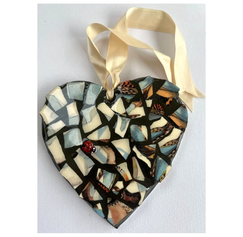 A beautiful heart shaped mosaic pendant a blue and speckled brown theme.