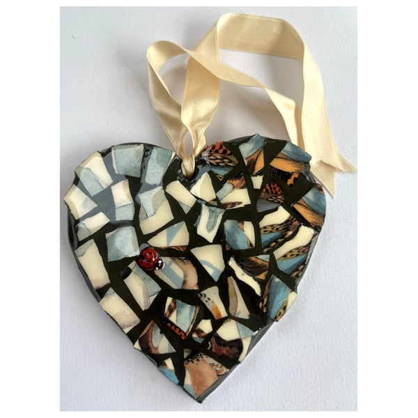 A beautiful heart shaped mosaic pendant a blue and speckled brown theme.
