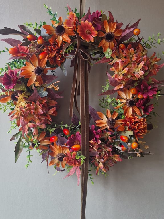 Lush autumn wreath with orange Hydrangea, Orange red berries, maple leaves.