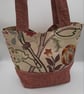 Red and beige floral fabric handbag.  