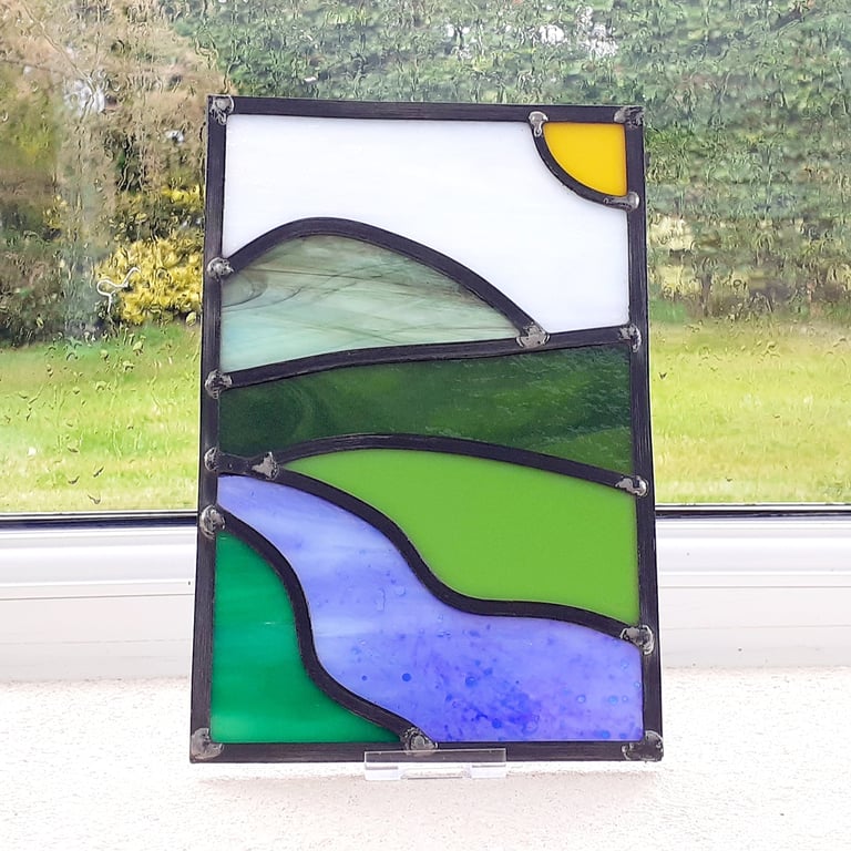 Leaded stained glass landscape panel, mountain and river under sunny skies