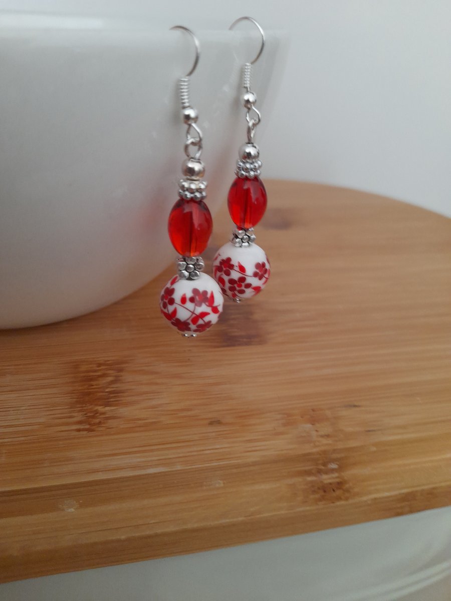 RED, WHITE AND SILVER CERAMIC BEAD EARRINGS.