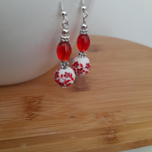 RED, WHITE AND SILVER CERAMIC BEAD EARRINGS.