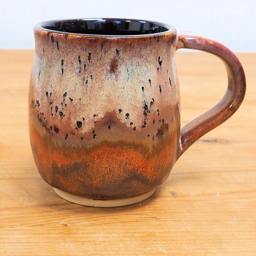 Large stoneware pottery mug finished in multi-coloured purple and copper glaze.