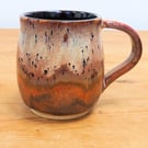 Large stoneware pottery mug finished in multi-coloured purple and copper glaze.