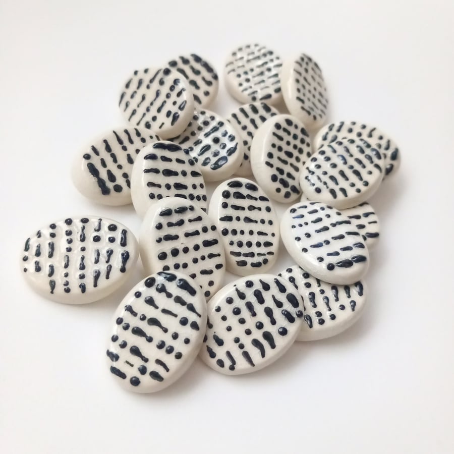 Morse code buttons. Black raised dots and dashes on a white oval background.