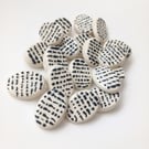 Morse code buttons. Black raised dots and dashes on a white oval background.
