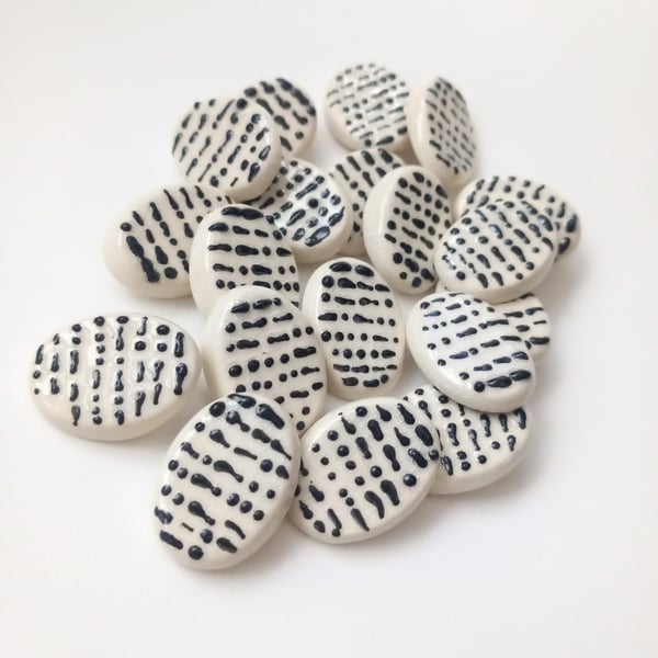 Morse code buttons. Black raised dots and dashes on a white oval background.