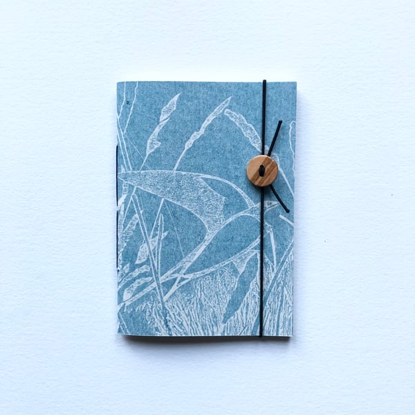 Notebook. Pocket sized. Swallow over grassland.