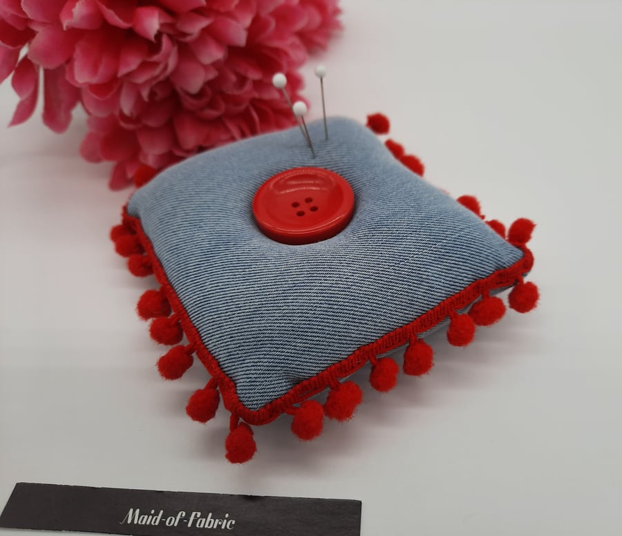 Pin cushion in denim with red bobble trim. 
