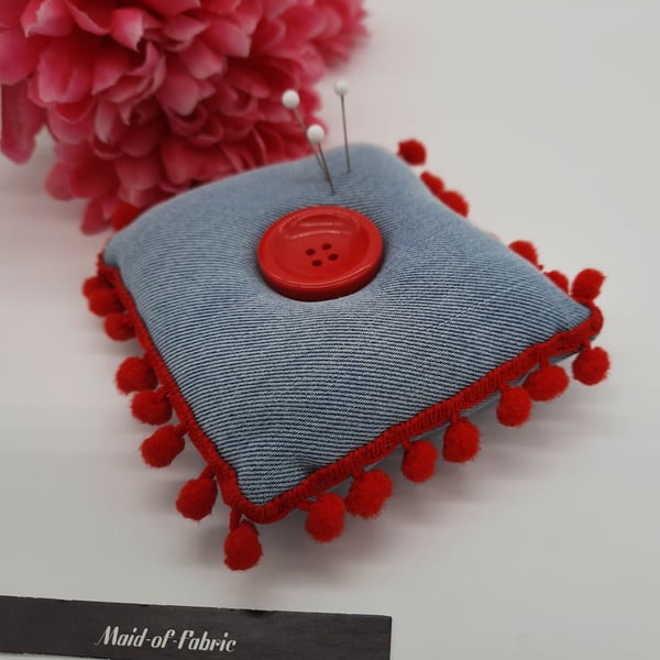 Pin cushion in denim with red bobble trim. 