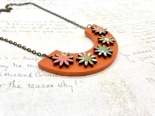 Orange, blue and green washi paper flowers on curve wooden necklace