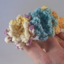 Crochet cuff with flower blooms in aqua, lemon and mauve
