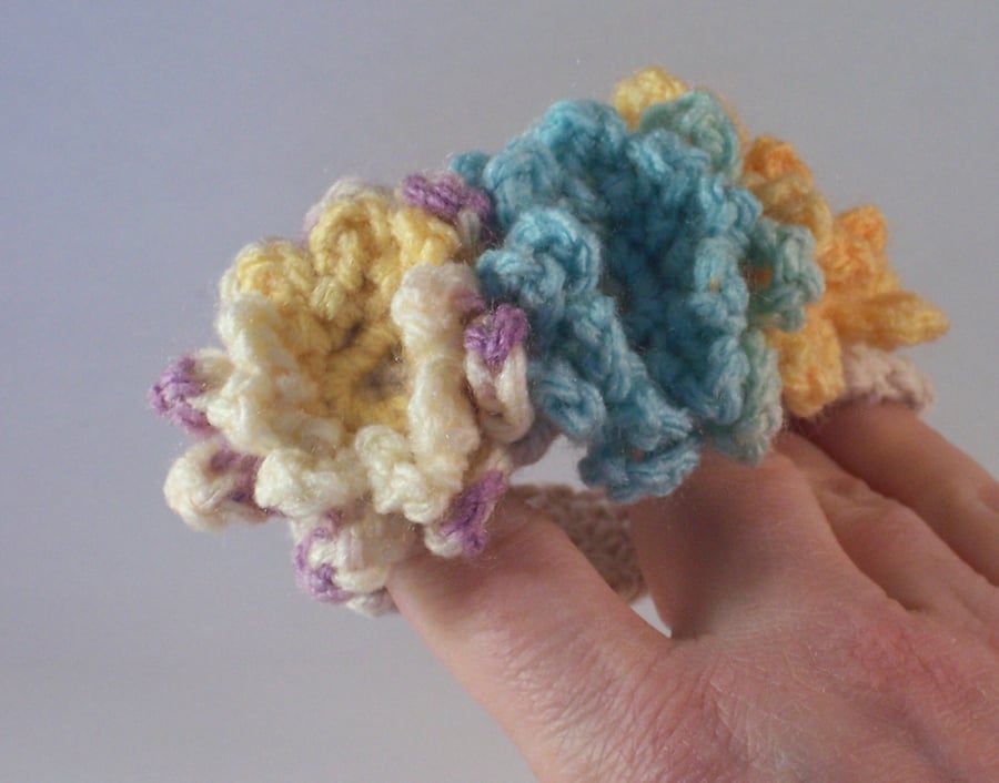 Crochet cuff with flower blooms in aqua, lemon and mauve