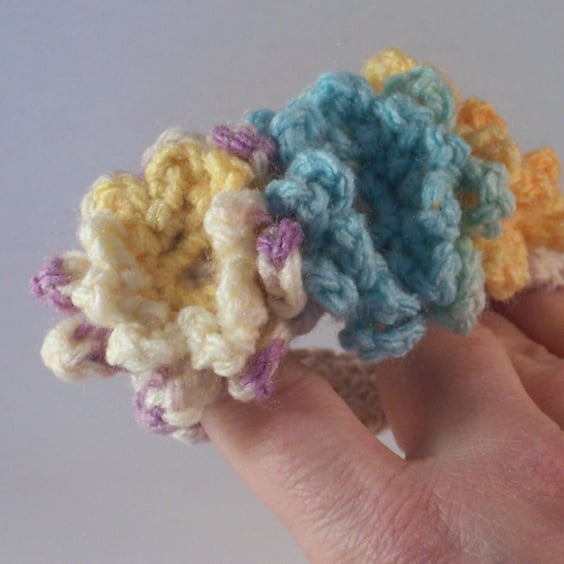 Crochet cuff with flower blooms in aqua, lemon and mauve