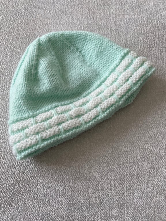 Aqua coloured baby’s hat with a cream border