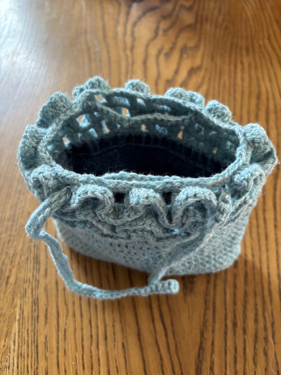 Pretty crochet handbag in pale blue recycled yarn, with a denim lining.