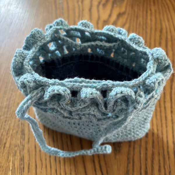 Pretty crochet handbag in pale blue recycled yarn, with a denim lining.