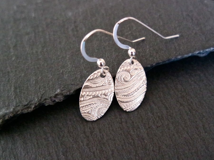 Oval silver earrings with a beach wave pattern pure silver clay sterling silver