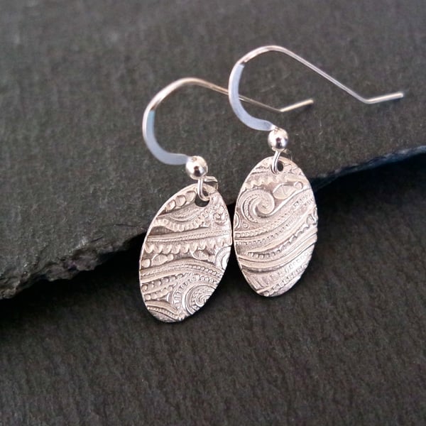 Oval silver earrings with a beach wave pattern pure silver clay sterling silver