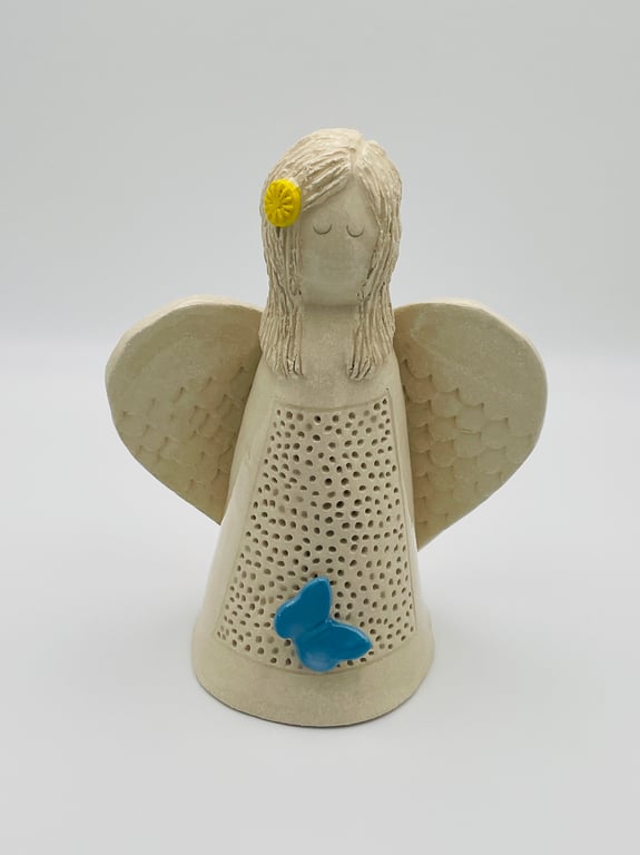 Angel sculpture with blue butterfly & yellow flower