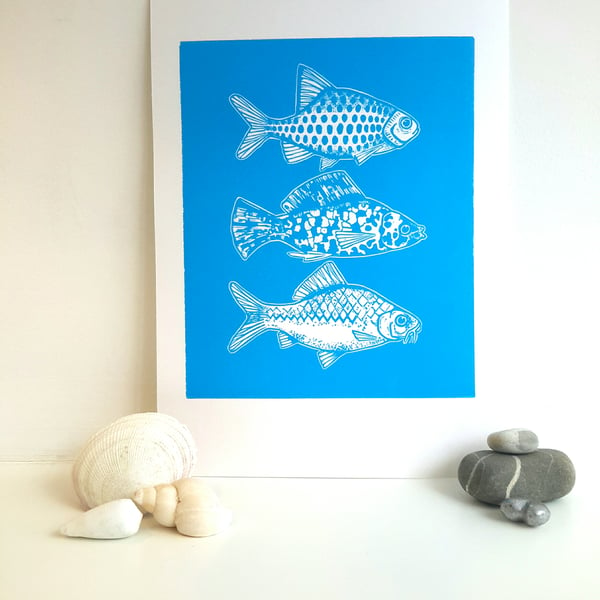 Linocut of three little fish handprinted in blue