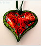 Handmade Small Metal Heart Decoration in red and green with a flower pattern.