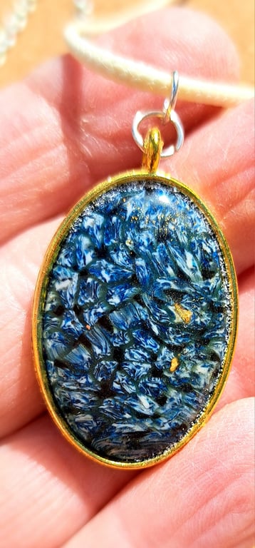Oval shaped pendant with blue, white and black polymer clay