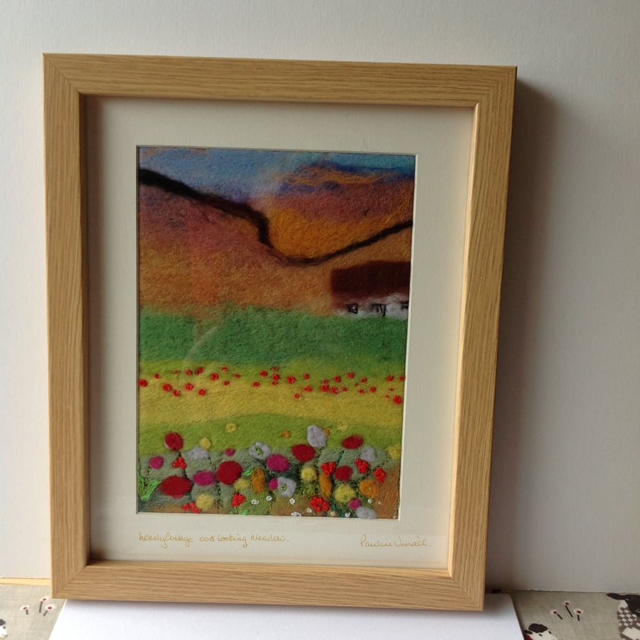 felt picture cottage over looking meadow.