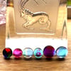A card of six curious mixed colour fused glass cabochons 