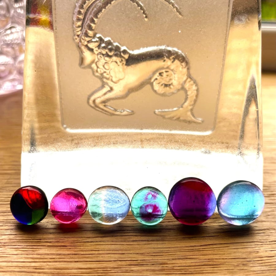 A card of six curious mixed colour fused glass cabochons 