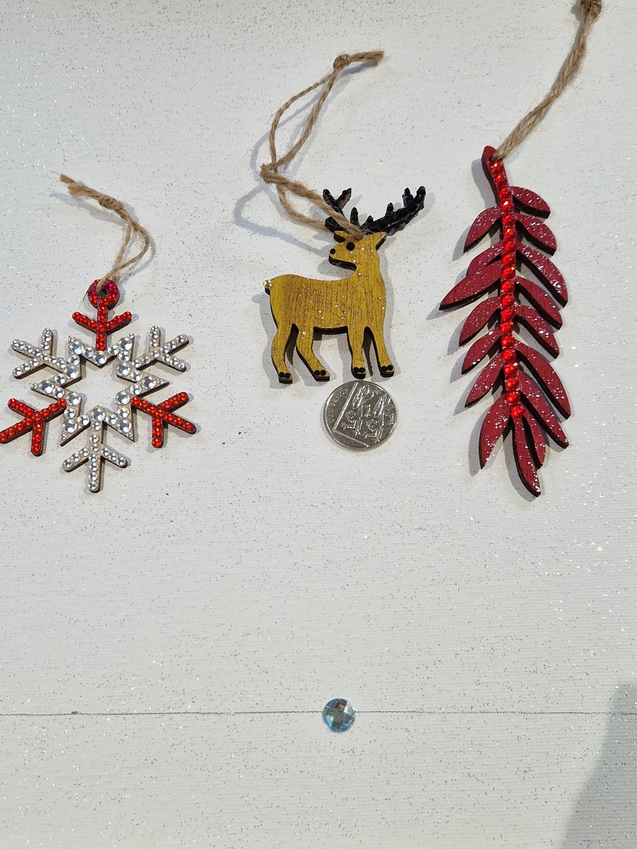 A set of three hand decorated wooden decorations.