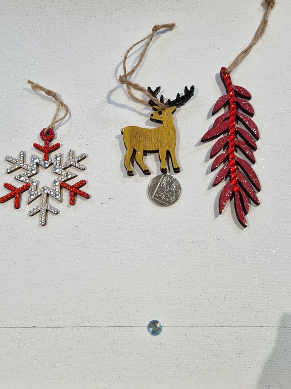 A set of three hand decorated wooden decorations.
