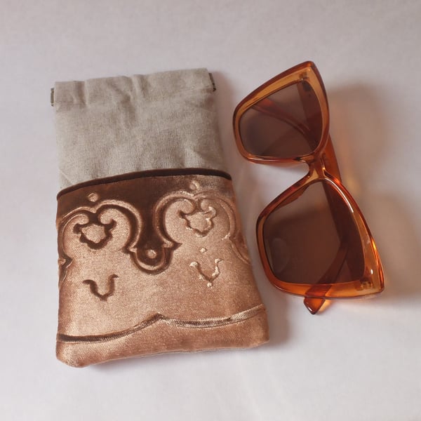 Gold glasses case with embossed velvet border and linen design, flex snap top.