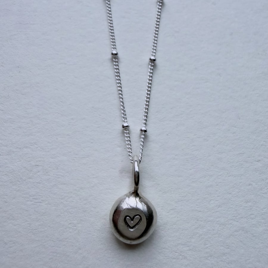 Handmade silver pebble pendant with heart