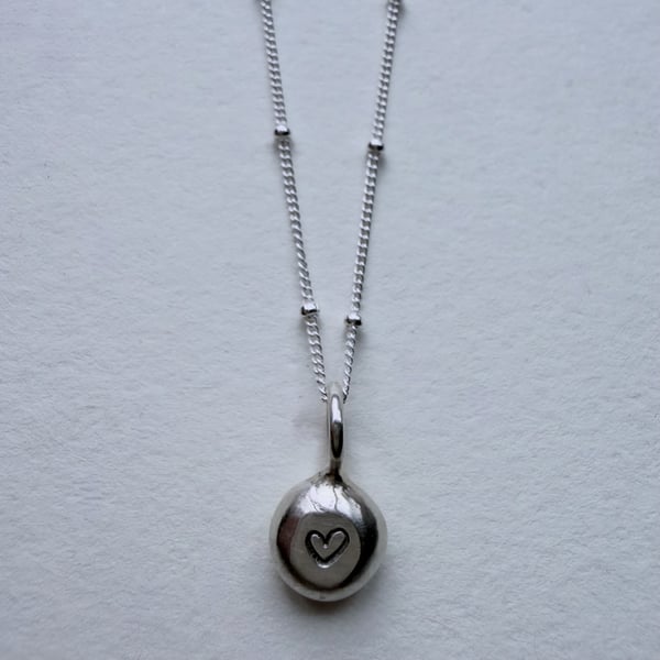 Handmade silver pebble pendant with heart