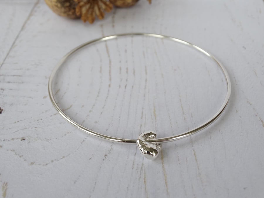 Silver bangle with single artefact charm in recycled silver