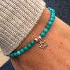 Turquoise stretch bracelet with silver lotus flower charm