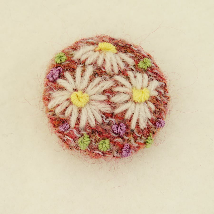 Daisy Brooch embroidered on knitted pink background