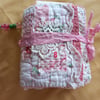 The pink and white needlecase, with pockets, pins, needles and  samples