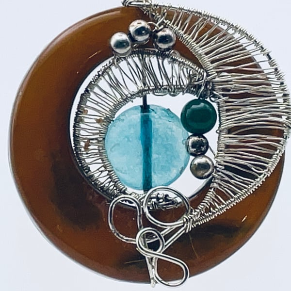 Burnt orange carnelian circlet with aqua colour disk and silver wired pendant