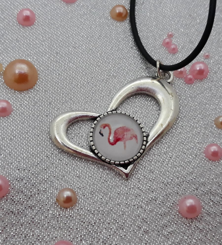 Flamingo set into heart pendant on a cord necklace.