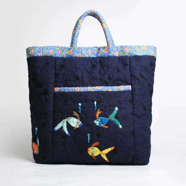 Navy blue bag with front pocket and four hand stitched fish