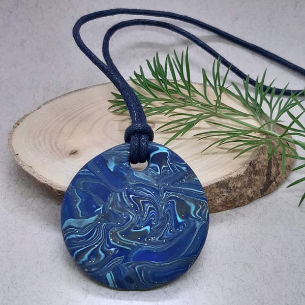 Round polymer clay pendant in a mixture of blues