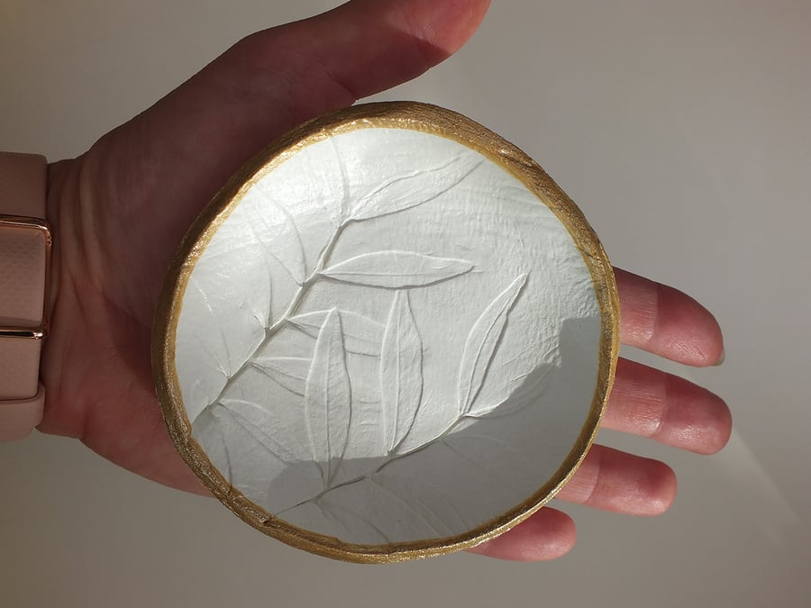 Thick white and gold trinket dish with plant imprint