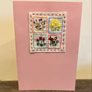 Handmade card with embroidery featuring a vignette of different flowers