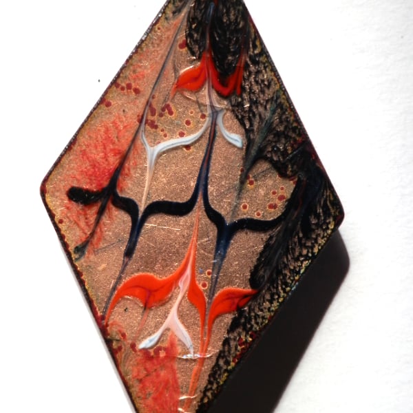 brooch: diamond shape - scrolled red and black over clear enamel