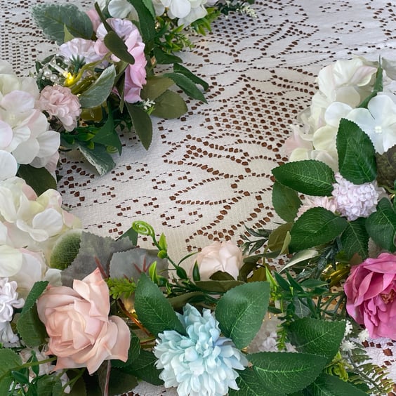 Handmade floral multi coloured, multi flowered garland table decoration.